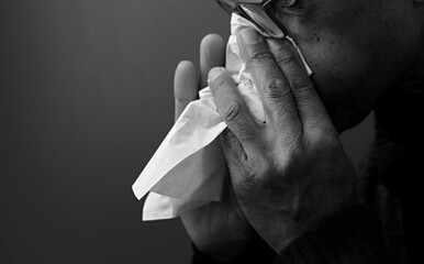 blowing nose after catching the cold and flu with grey background with people stock image stock...