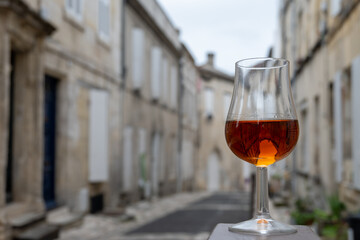Tasting of cognac alcohol drink, view on old streets, houses in town Cognac, Grand Champagne, Charente, strong spirits distillation industry, France