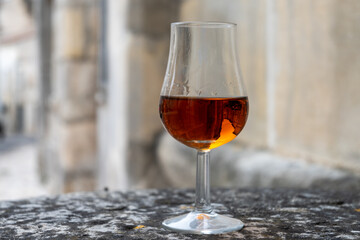 Tasting of cognac alcohol drink and view on old streets and houses in town Cognac, Grand Champagne, Charente, strong spirits distillation industry, France