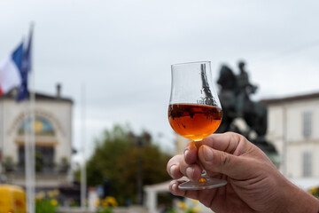 Tasting of cognac alcohol drink and view on old streets and houses in town Cognac, Grand Champagne,...