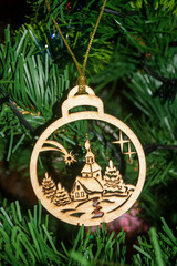 Wooden decoration ball on the Christmas tree. The decoration is a ball with a house church...