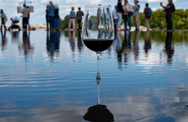 Tasting of Bordeaux blended red wine with wine city Bordeaux on background, left bank of Gironde...