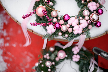 Romantic wreath of green fir branches decorated by soft pink toys