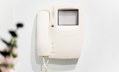 Photo of a telephone with a video camera on the wall at the entrance of a house. Video intercom....