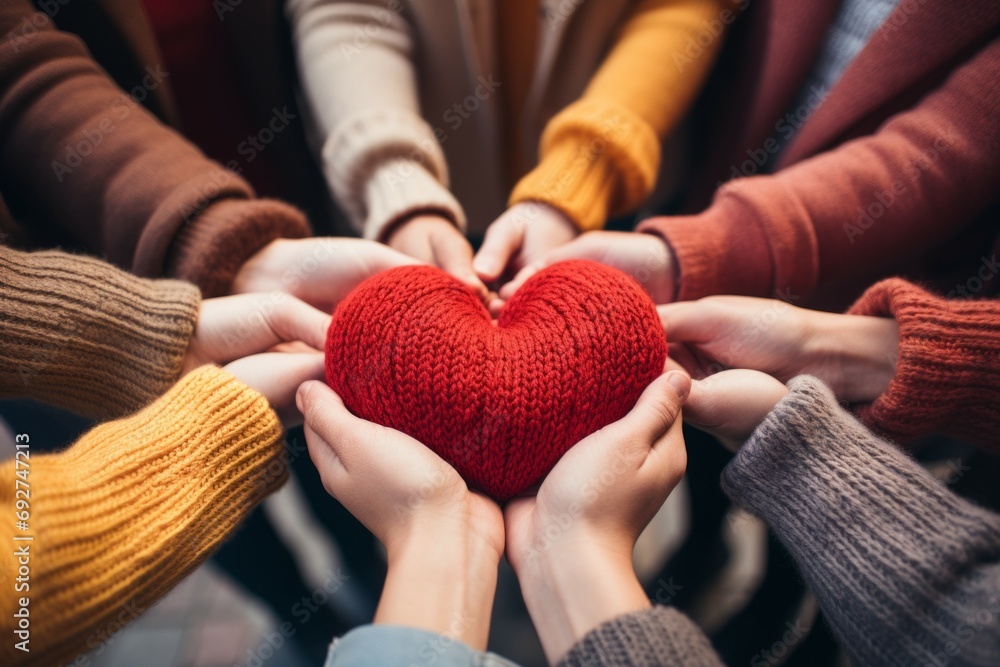 Poster hands of a team of people hold a heart. background with selective focus and copy space