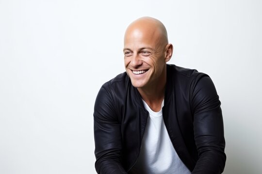 Portrait of a happy bald man in a black jacket on a white background