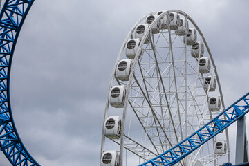 Modern white Ferris wheel in the central park against sky. Entertainment, attraction, amusement park. 