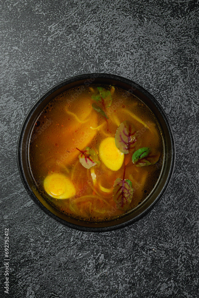 Wall mural Traditional Russian and Ukrainian cuisine, appetizing chicken soup with egg on a dark background - Wall murals