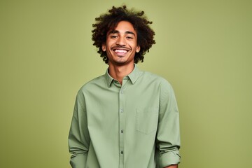 Fototapeta na wymiar Portrait of a happy young african american man with curly hair on green background