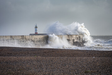 Fototapeta na wymiar Stormy weather in Newhaven, East Sussex, England in autumn. View of the jetty and the lighthouse.