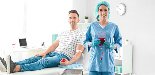 Portrait of nurse and young man donating blood in hospital
