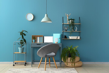 Stylish interior of room with comfortable workplace and houseplants - obrazy, fototapety, plakaty