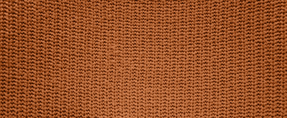Background of knitted wool texture in the new trendy color of 2024 year Peach Fuzz. Texture top view. Blog backdrop for text signs design. Abstract wallpaper, textile surface.