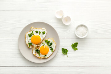 Cooking fried eggs with coriander, top view. Breakfasr background
