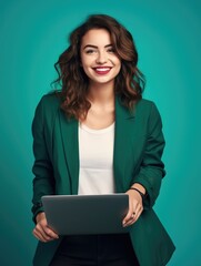 A woman in a green jacket holding a laptop.