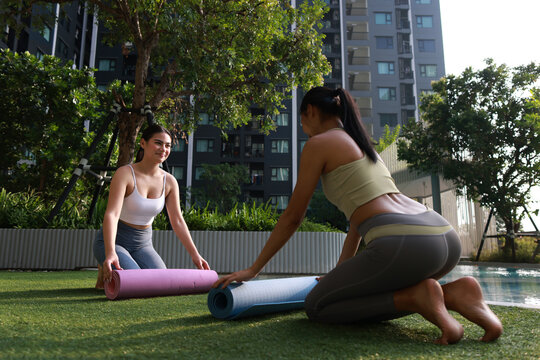 A couple young woman with sport uniform prepare yoga mats at the poolside, Yoga exercise
