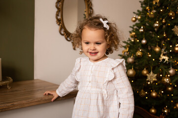 young cute girl s at home in the Christmas decorated kitchen.
