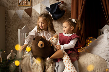 baby girls playing in children's room, on bed at home with toy animal