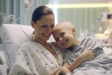 little boy with cancer with mother woman in hospital bed smiling