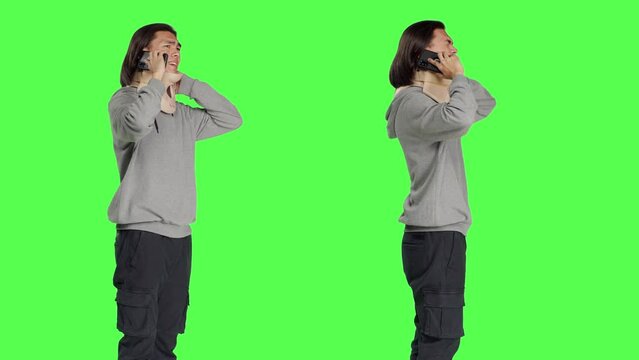 Young man having neck brace makes phone call informing people about his vertebral fracture accident. Greenscreen of wounded person wearing cervical foam collar, speaking on telephone.