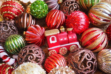 Fototapeta na wymiar New Year's Christmas balls and decorations close up. A lot of decor of gold, red, yellow, brown, green, silver. Striped Christmas balls lie in a bunch. Festive beautiful colorful background. Design