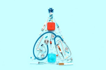 Christmas tree made of medical supplies, medicines and decorations on color background