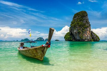Long tail boat on tropical beach (Pranang beach) and rock, Krabi, Thailand