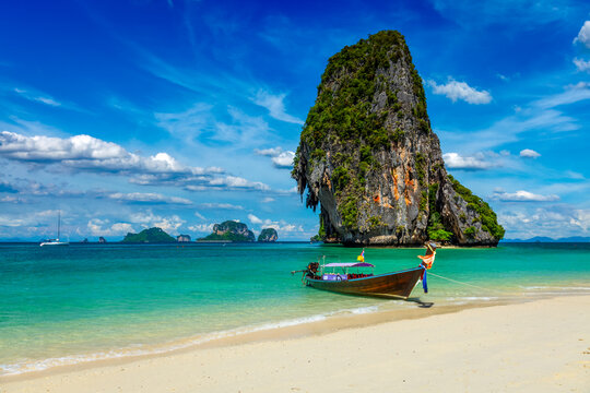 Long tail boat on tropical beach with limestone rock, Krabi, Thailand