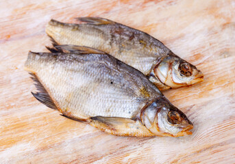 Dried salted bream lying on a wooden table. Close-up image..