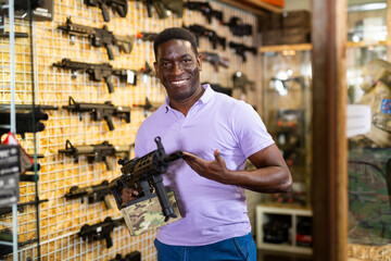Portrait of man which is choosing air-powered gun in army market