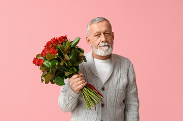 Mature man with bouquet of roses on pink background. Valentine's day celebration