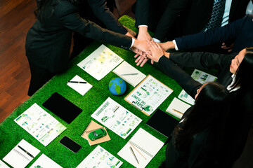 Business synergy of business people holding hand together as team building for eco regulation for...