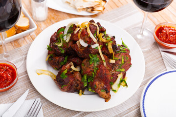 Spicy barbecued pork meat served with vegetables and fresh herbs