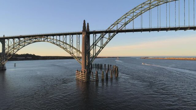 Aerial Drone Video- Yaquina Bay Bridge Sunrise- Newport Oregon-  South support - Slow dolly-in - Boats in background V09