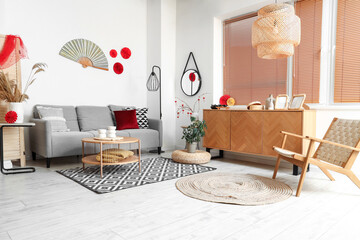 Interior of festive living room with grey sofa, coffee table and traditional Chinese decorations....