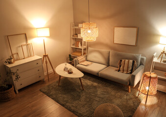 Interior of modern living room with grey sofa, coffee table and glowing lamps at evening