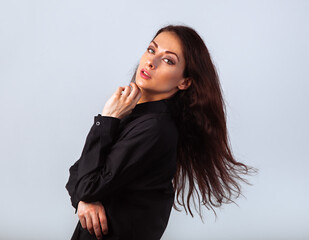 Beautiful confident woman looking and moving with windy shake long hair in black cotton style shirt...