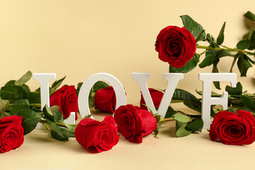 Red roses with text LOVE on yellow background. Valentine's day concept