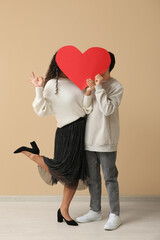 Couple with red heart for Valentine's day near beige wall