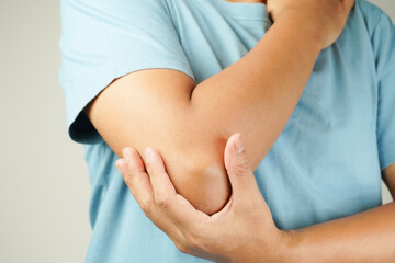 Health concept, person with elbow pain, man holding hand on elbow with pain, bone arthritis