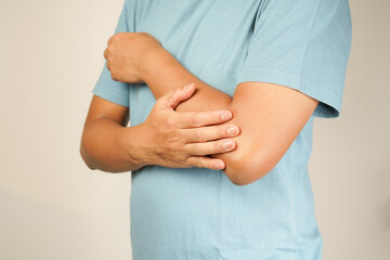 Health concept, person with elbow pain, man holding hand on elbow with pain, bone arthritis