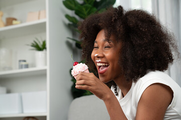 Funny African on mess face with whipped cream presenting cupcake topping on cherry in concept...