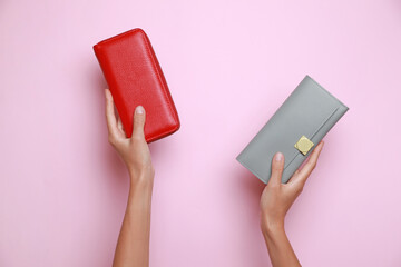 Woman holding leather purses on pink background, closeup