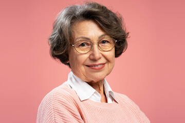 Closeup portrait smiling senior woman, cute happy grandmother wearing sweater, eyeglasses looking...