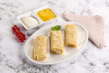 Homemade stuffed pancakes with honey and cream sour