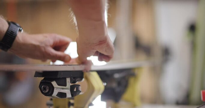 Man servicing skis. Abstract male hands working with special equipment. Removing excess wax from skiing surface. Close up video recorded with cinema camera.