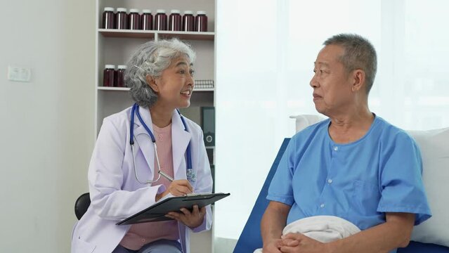 A caring retired female doctor provides medical care to an elderly Asian man lying in a hospital bed. Emphasizing the importance of health care Treatment concept, health insurance.