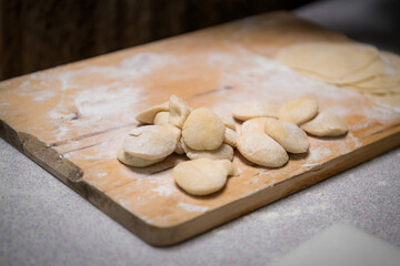 Fototapeta na wymiar Process of making chinese dumplings. Raw dough on wooden chopping board.