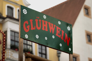 Glühwein (mulled wine) sign in a city with a christmas market. The hot beverage with alcohol is...