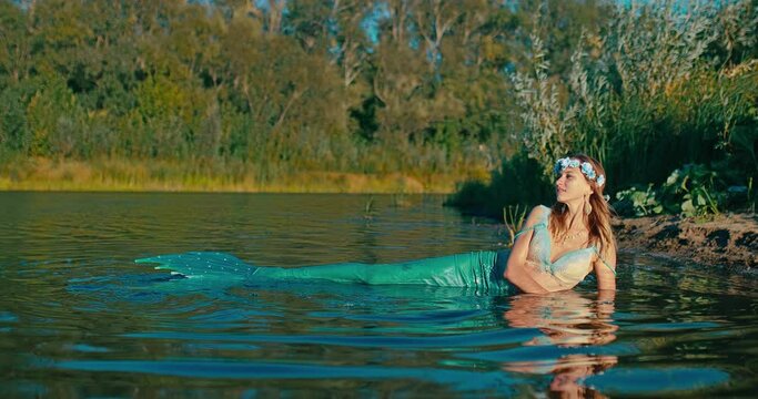 beautiful undine from old east Slavic fairy tales swimming in lake and lying on coast, 4K, Prores